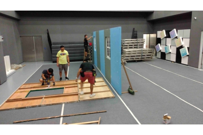 工作人員搭建布景和粉刷幕墻。1-1110x624